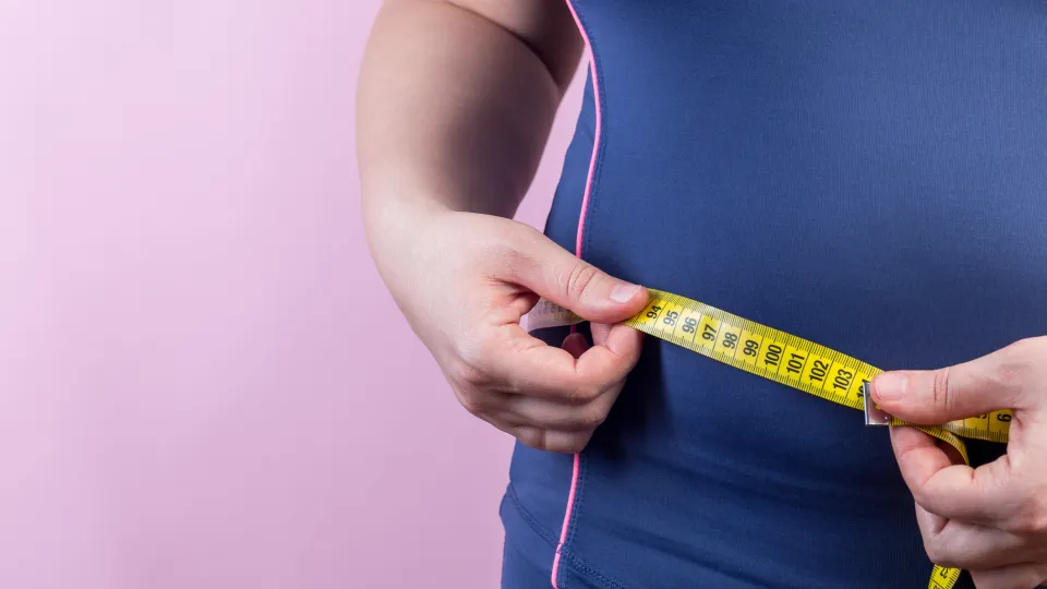 Photograph of a person measuring waist circumference.