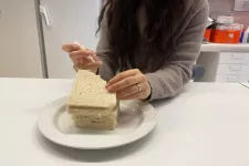 Photo of a woman who eats bread. 