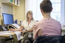 Photograph of a research nurse and a study participant.